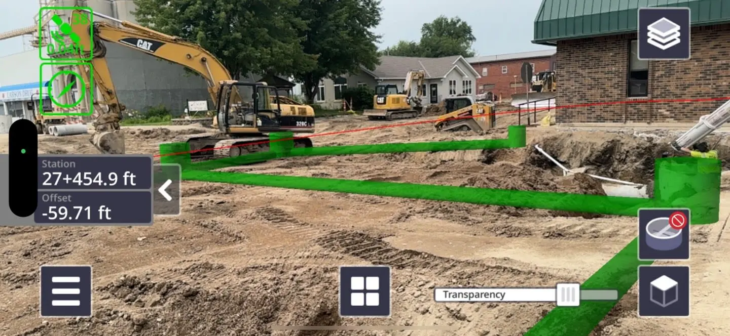 AR construction app overlay on a dig site with CAT excavators, showing green pipeline routes and station offset data.